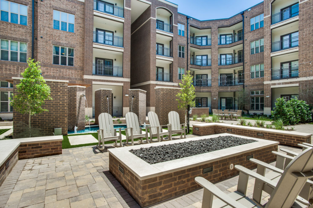 Community brick courtyard enclosure with fire pit, lawn chairs, and fountains