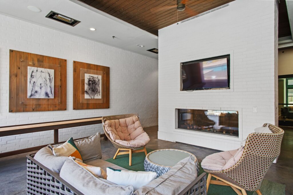 exterior pool lounge area with seating, games, shuffleboard, and tv