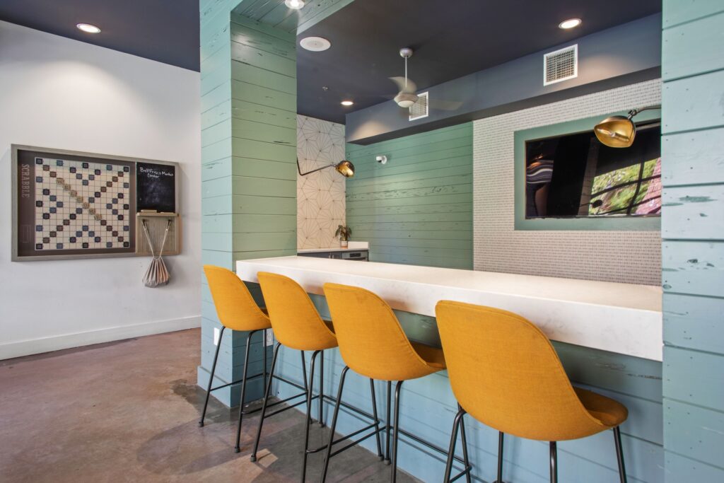 interior resident gaming lounge with bar, bar seating, game board, and tv