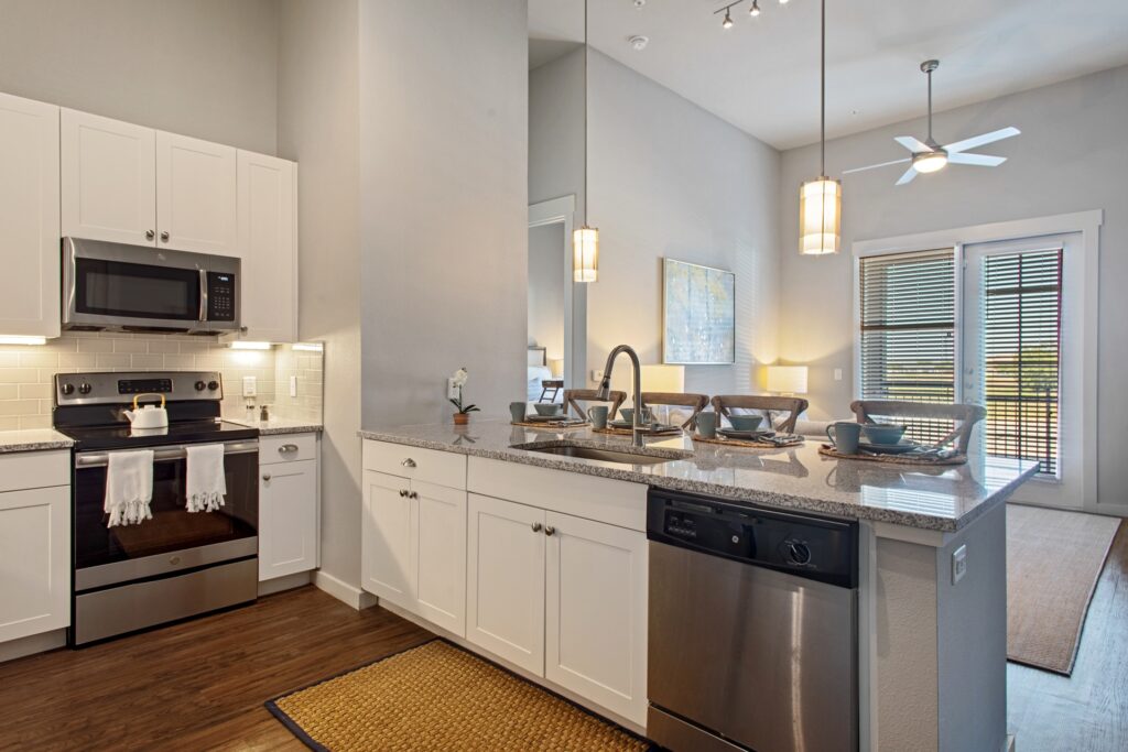 interior model unit with white cabinetry overlooking living room